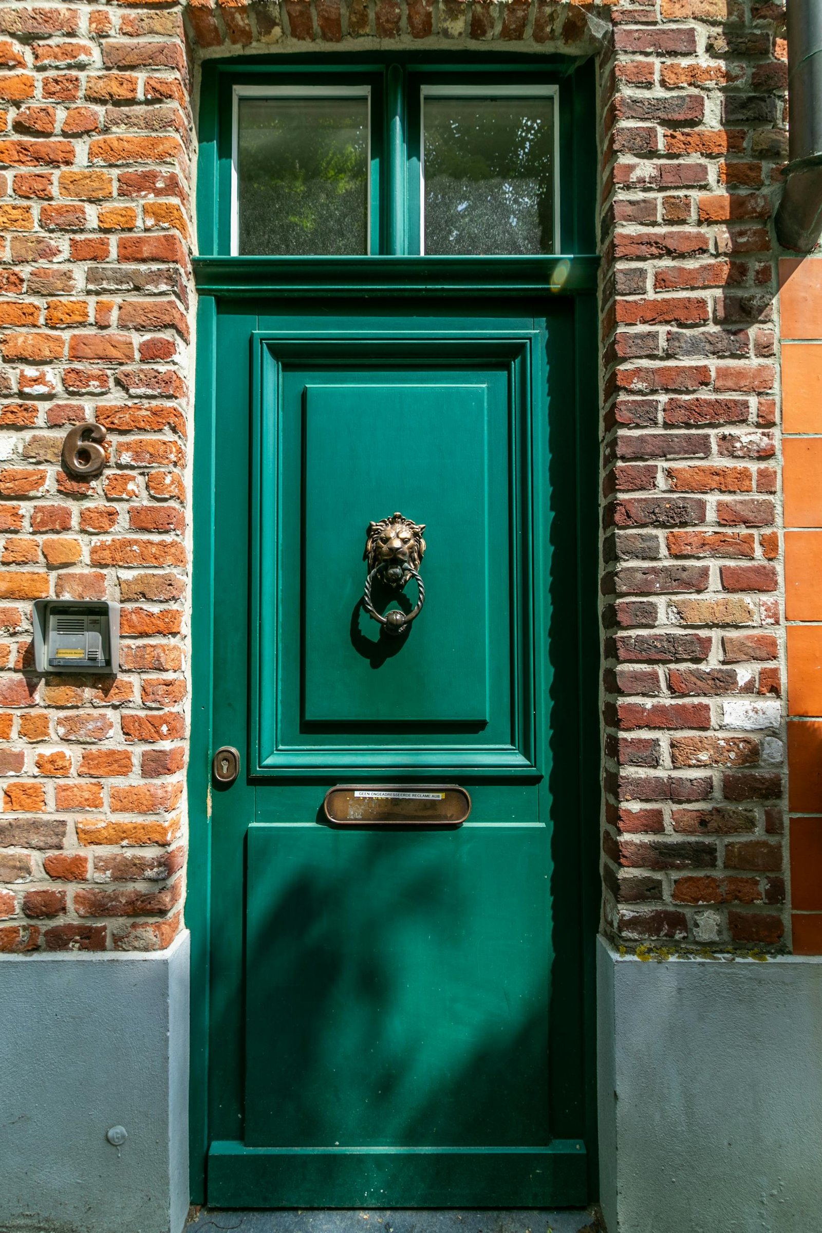 Green Wooden Door With Brown Brick Wall