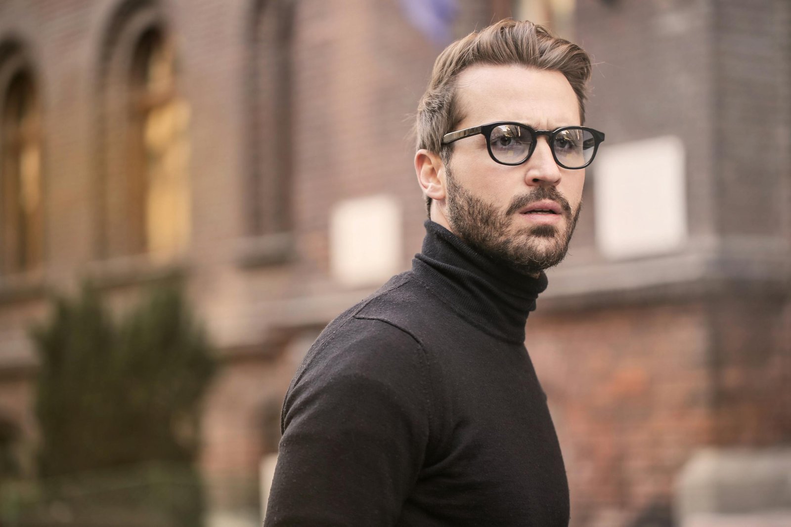 Man Standing Near Building White Black Turtleneck Shirt