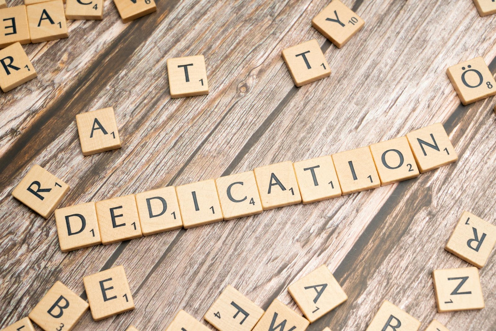 The word dedication spelled out in scrabble letters