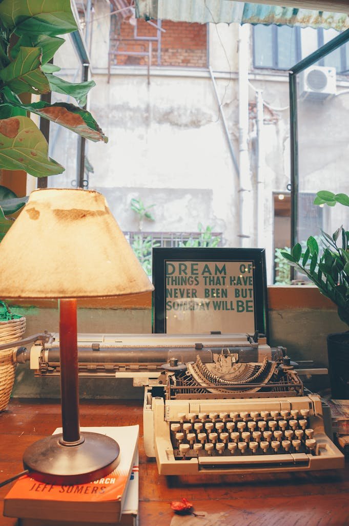 White Typewriter Beside Table Lamp