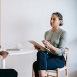 Ethnic female psychotherapist listening to black clients explanation