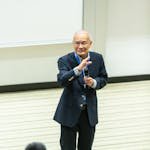 Man Standing in Front of Chairs and People