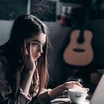 Photo of Woman Lying on Bed While Using Laptop